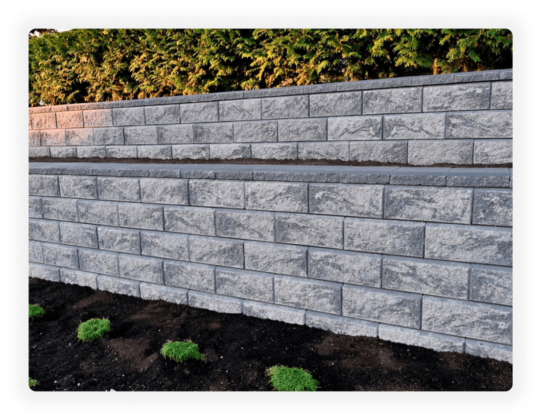 Gray concrete block retaining wall installation by London Retaining Walls